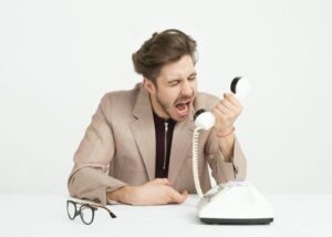 Homme criant au téléphone.